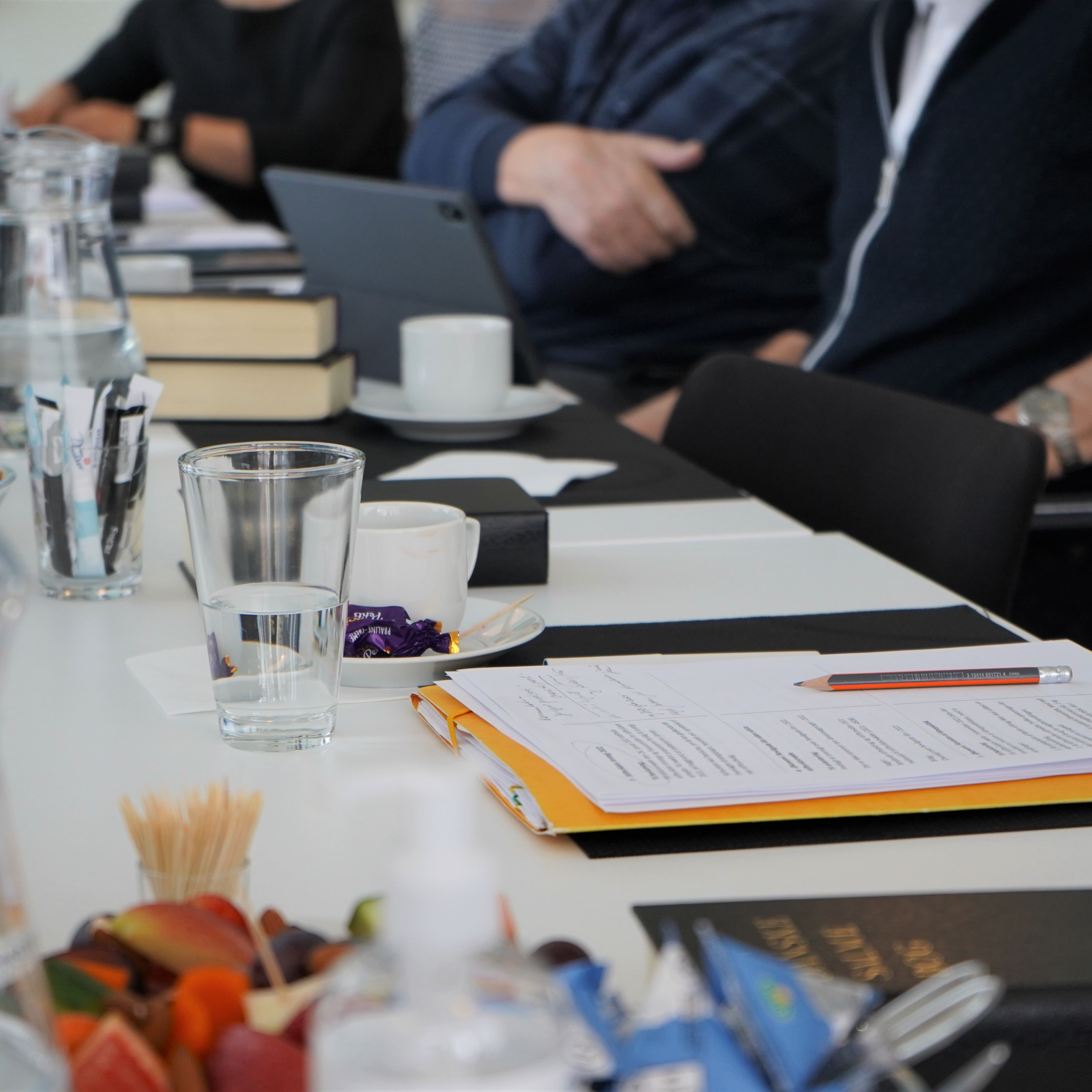 mødebord folk der lytter og tager notater