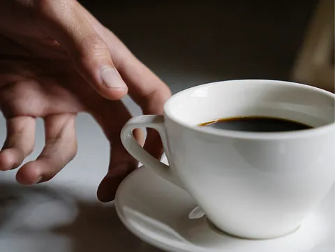 Hånd der rør kaffekop